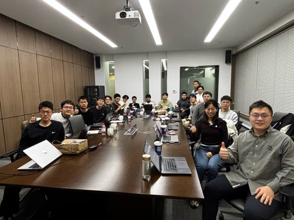 DENG Lab members gathered around a conference table.